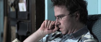 Movie still from “Down Terrace” (2009), directed by Ben Wheatley – A person wearing glasses; Close Up shot, Low angle