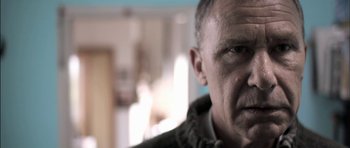 Movie still from “Down Terrace” (2009), directed by Ben Wheatley – A man's face in a room; Close Up shot, Low angle