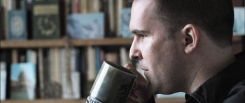 Movie still from “Down Terrace” (2009), directed by Ben Wheatley – A person drinking from a mug; Close Up shot, Low angle