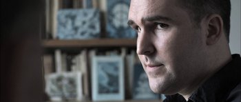 Movie still from “Down Terrace” (2009), directed by Ben Wheatley – A man's face in front of a book shelf; Close Up shot, Low angle