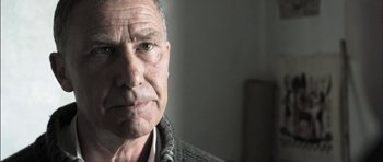 Movie still from “Down Terrace” (2009), directed by Ben Wheatley – An older man is looking into the camera; Close Up shot, Low angle