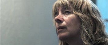 Movie still from “Down Terrace” (2009), directed by Ben Wheatley – A woman's face looking upward; Close Up shot, Low angle