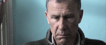 Movie still from “Down Terrace” (2009), directed by Ben Wheatley – An older man with a serious look on his face; Close Up shot, Low angle