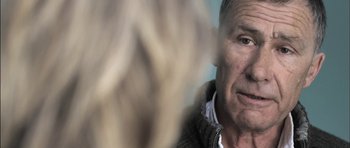 Movie still from “Down Terrace” (2009), directed by Ben Wheatley – An older man is looking at the camera; Close Up shot, Over the shoulder angle