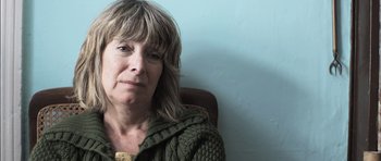 Movie still from “Down Terrace” (2009), directed by Ben Wheatley – A person sitting in a chair wearing a sweater; Close Up shot, Low angle