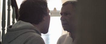 Movie still from “Down Terrace” (2009), directed by Ben Wheatley – Two men face each other in front of a window; Close Up shot, Over the shoulder angle