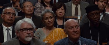 Movie still from “Downsizing” (2017), directed by Alexander Payne – An older woman is standing in front of an older man; Close Up shot, Over the shoulder angle