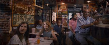 Movie still from “Downsizing” (2017), directed by Alexander Payne – A group of people sitting at a table in a restaurant; Wide shot, Over the shoulder angle