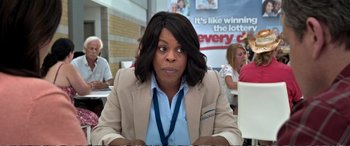 Movie still from “Downsizing” (2017), directed by Alexander Payne – A woman sitting at a table; Close Up shot, Over the shoulder angle