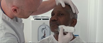 Movie still from “Downsizing” (2017), directed by Alexander Payne – An older man getting his face shaved by a doctor; Close Up shot, Over the shoulder angle