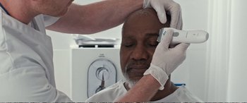 Movie still from “Downsizing” (2017), directed by Alexander Payne – A man getting his head shaved by a doctor; Close Up shot, Overhead angle