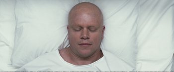 Movie still from “Downsizing” (2017), directed by Alexander Payne – A bald man laying in bed with his eyes closed; Close Up shot, Overhead angle