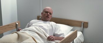 Movie still from “Downsizing” (2017), directed by Alexander Payne – A bald man laying in a hospital bed; Medium shot, High angle