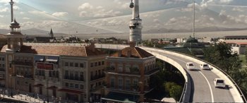 Movie still from “Downsizing” (2017), directed by Alexander Payne – An aerial view of a building with a sky lift in the background; Extreme Wide shot, High angle