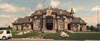 Movie still from “Downsizing” (2017), directed by Alexander Payne – A man standing in front of a large house; Extreme Wide shot, Low angle