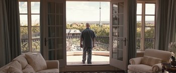 Movie still from “Downsizing” (2017), directed by Alexander Payne – An older man standing in front of an open window; Wide shot, Low angle