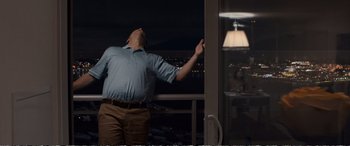 Movie still from “Downsizing” (2017), directed by Alexander Payne – A man standing in front of a window at night; Medium shot, Low angle