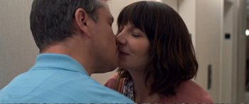 Movie still from “Downsizing” (2017), directed by Alexander Payne – A man and a woman kissing each other in front of a wall; Close Up shot, Low angle