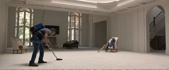 Movie still from “Downsizing” (2017), directed by Alexander Payne – Two people are vacuuming in a large room; Wide shot, High angle