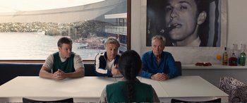 Movie still from “Downsizing” (2017), directed by Alexander Payne – A group of people sitting around a table; Medium shot, Over the shoulder angle