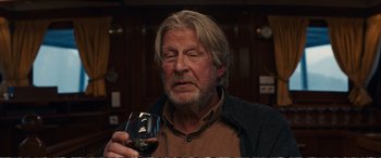 Movie still from “Downsizing” (2017), directed by Alexander Payne – An older man holding a glass of red wine; Close Up shot, Over the shoulder angle