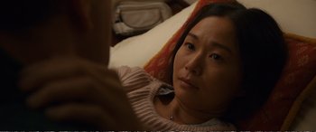 Movie still from “Downsizing” (2017), directed by Alexander Payne – A woman laying in a bed looking at the camera; Close Up shot, Over the shoulder angle