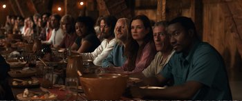 Movie still from “Downsizing” (2017), directed by Alexander Payne – A group of people sitting around a table; Medium shot, Over the shoulder angle