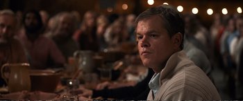 Movie still from “Downsizing” (2017), directed by Alexander Payne – A person sitting at a table in a restaurant; Close Up shot, Over the shoulder angle