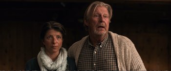 Movie still from “Downsizing” (2017), directed by Alexander Payne – An older man and a younger woman standing next to each other; Medium shot, Low angle