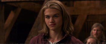 Movie still from “Downsizing” (2017), directed by Alexander Payne – A man with long blonde hair wearing a maroon shirt; Close Up shot, Over the shoulder angle