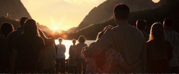 Movie still from “Downsizing” (2017), directed by Alexander Payne – A group of people standing on a beach at sunset; Extreme Wide shot, High angle