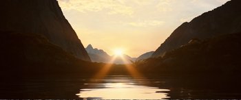 Movie still from “Downsizing” (2017), directed by Alexander Payne – The sun is setting over a mountain range and a lake; Extreme Wide shot, Low angle