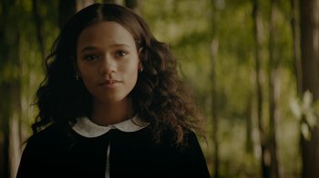 A young woman with long hair and a white collar