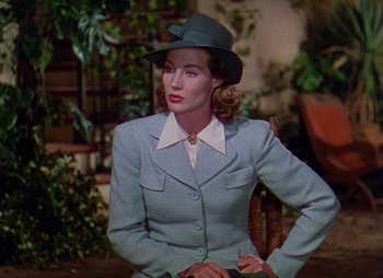 Movie still from “Dr. Cyclops” (1940), directed by Ernest B. Schoedsack – A woman wearing a hat and a suit; Medium shot, Low angle
