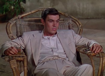 Movie still from “Dr. Cyclops” (1940), directed by Ernest B. Schoedsack – A man in a suit sitting in a wicker chair; Medium shot, High angle