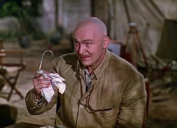 Movie still from “Dr. Cyclops” (1940), directed by Ernest B. Schoedsack – A bald man holding a wire in his hand; Medium shot, High angle