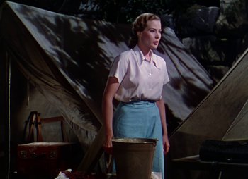 Movie still from “Dr. Cyclops” (1940), directed by Ernest B. Schoedsack – A woman standing in front of a wall holding a bucket; Medium shot, Low angle