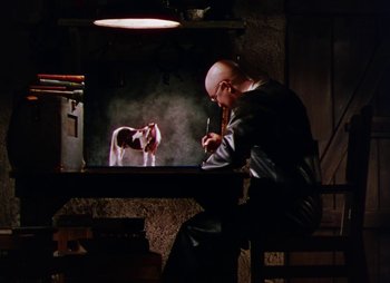 Movie still from “Dr. Cyclops” (1940), directed by Ernest B. Schoedsack – A man sitting in front of a horse in a dark room; Wide shot, Low angle