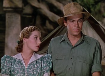 Movie still from “Dr. Cyclops” (1940), directed by Ernest B. Schoedsack – A man and a woman standing next to each other in front of a tent; Medium shot, Low angle