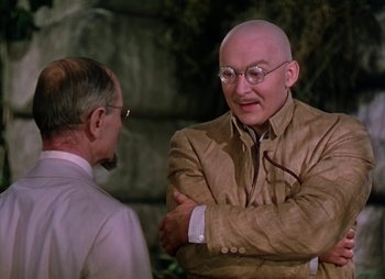 Movie still from “Dr. Cyclops” (1940), directed by Ernest B. Schoedsack – A man with a bald head talking to another man; Medium shot, Over the shoulder angle