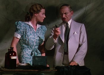 Movie still from “Dr. Cyclops” (1940), directed by Ernest B. Schoedsack – An older man and a young woman are standing next to each other; Medium shot, Low angle