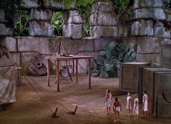 Movie still from “Dr. Cyclops” (1940), directed by Ernest B. Schoedsack – A group of people standing around in an outdoor setting; Extreme Wide shot, High angle