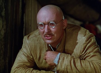 Movie still from “Dr. Cyclops” (1940), directed by Ernest B. Schoedsack – A bald man in a suit and glasses; Close Up shot, Low angle