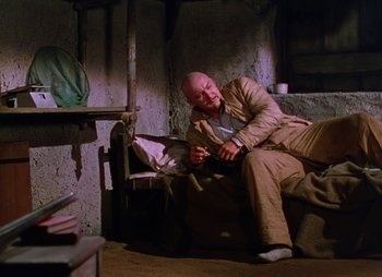 Movie still from “Dr. Cyclops” (1940), directed by Ernest B. Schoedsack – A man sitting on a chair in a room; Wide shot, Low angle