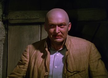 Movie still from “Dr. Cyclops” (1940), directed by Ernest B. Schoedsack – A man with a bald head wearing a brown jacket; Close Up shot, Low angle
