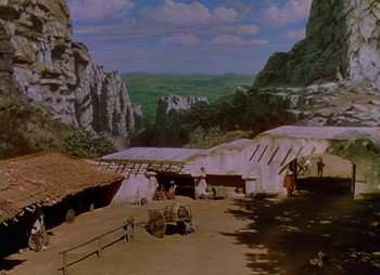 Movie still from “Dr. Cyclops” (1940), directed by Ernest B. Schoedsack – A painting of an old western town with mountains in the background; Extreme Wide shot, High angle