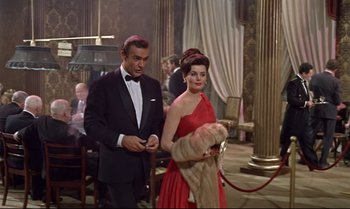 Movie still from “Dr. No” (1962), directed by Terence Young – A man and a woman standing next to each other in a room; Medium shot, Low angle