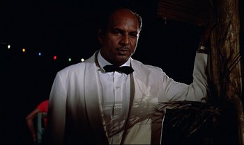 Movie still from “Dr. No” (1962), directed by Terence Young – A man in a white suit and a bow tie; Medium shot, Low angle