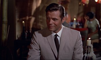 Movie still from “Dr. No” (1962), directed by Terence Young – A person wearing a suit and tie; Close Up shot, Over the shoulder angle
