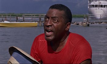 Movie still from “Dr. No” (1962), directed by Terence Young – A man in a red t - shirt is in the water; Close Up shot, Low angle